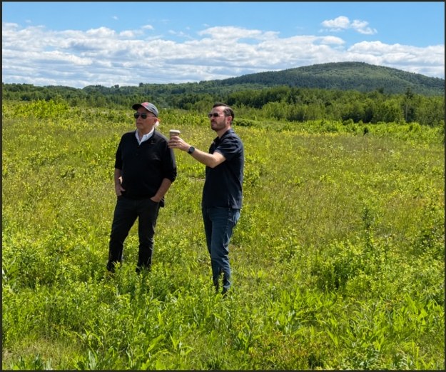 Doug Beane and a colleague reviewing the site in a field near the airport